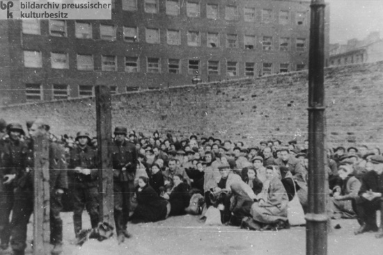 Suppression of the Warsaw Ghetto Uprising: Jews Forcibly Assembled Near the Wall of the Ghetto Await Deportation (May 1943)